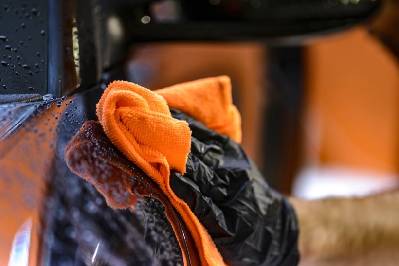 Detailing a car with a microfiber towel